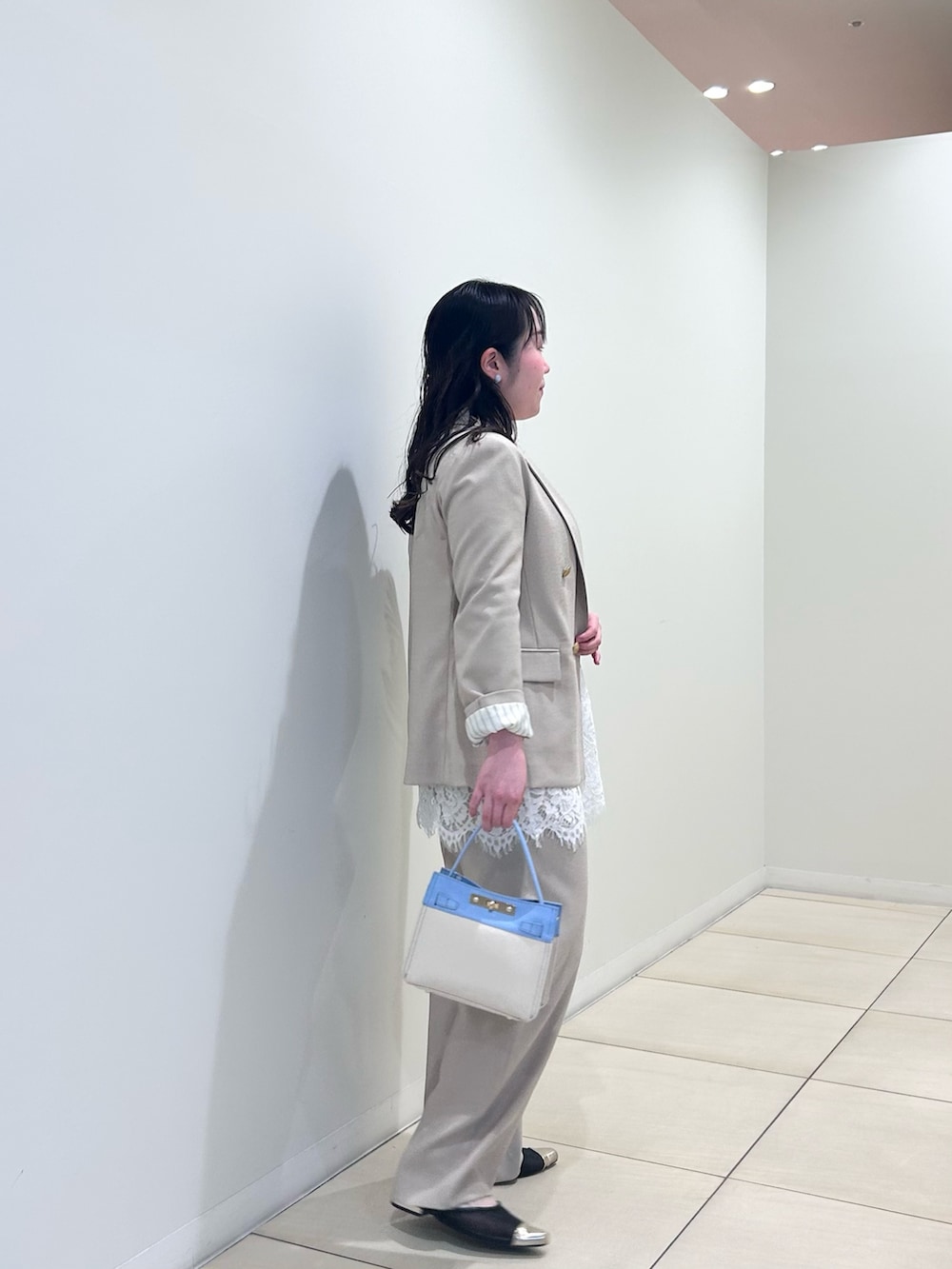 ベージュ系のテーラードジャケット、ベージュ系のその他パンツ、ホワイト系のニット/セーターを着用したレディースの春コーディネートの2枚目の写真