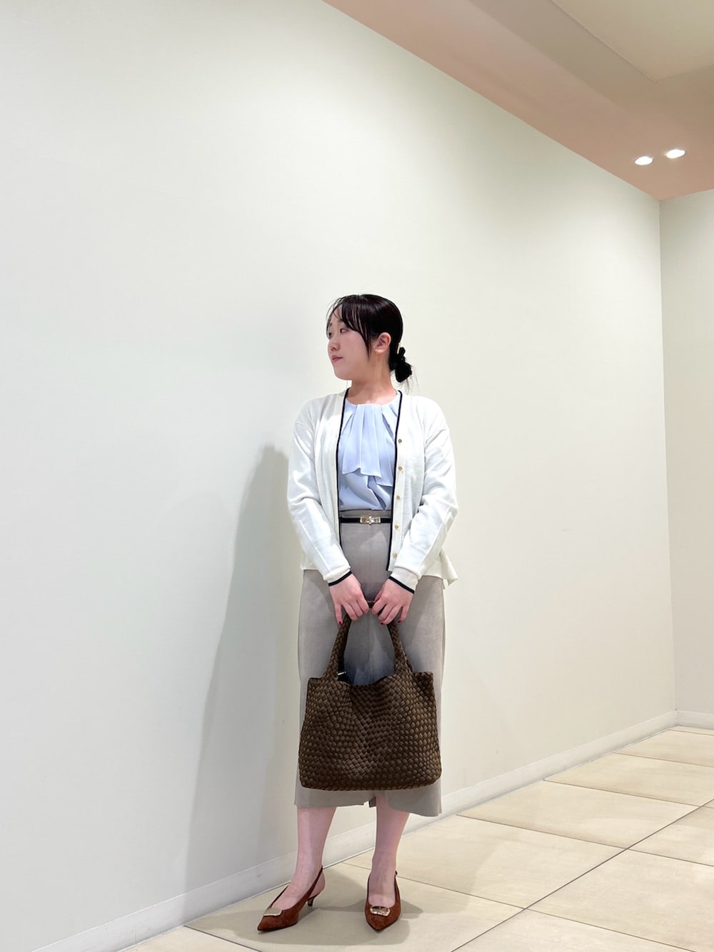 ホワイト系のカーディガン/ボレロ、ブルー系のシャツ/ブラウス、ベージュ系のスカートを着用したレディースの秋コーディネートの5枚目の写真