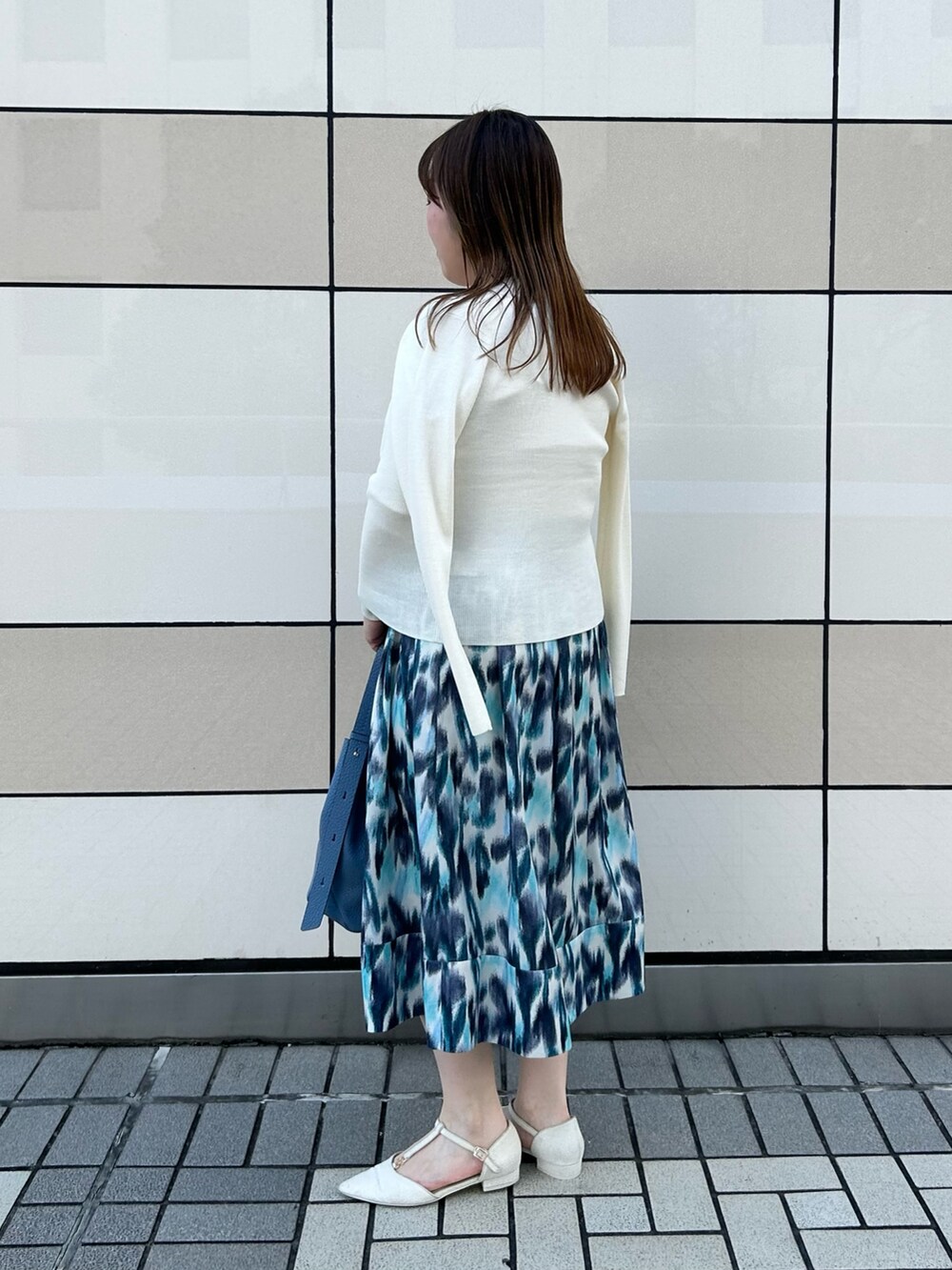 ホワイト系のカーディガン/ボレロ、ホワイト系のニット/セーター、ブルー系のスカートを着用したレディースの秋コーディネートの3枚目の写真
