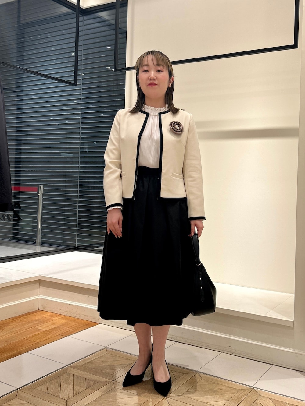 ホワイト系のノーカラージャケット、ホワイト系のシャツ/ブラウス、ブラック系のショルダーバッグを着用したレディースの冬コーディネートの8枚目の写真