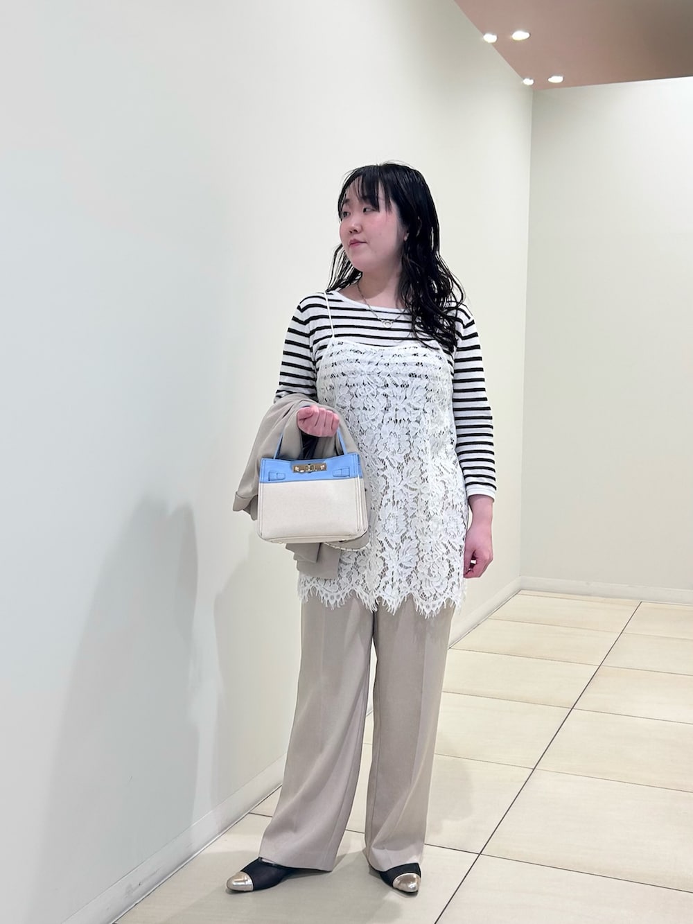 ホワイト系のキャミソール、ホワイト系のニット/セーター、ベージュ系のテーラードジャケットを着用したレディースの春コーディネートの10枚目の写真