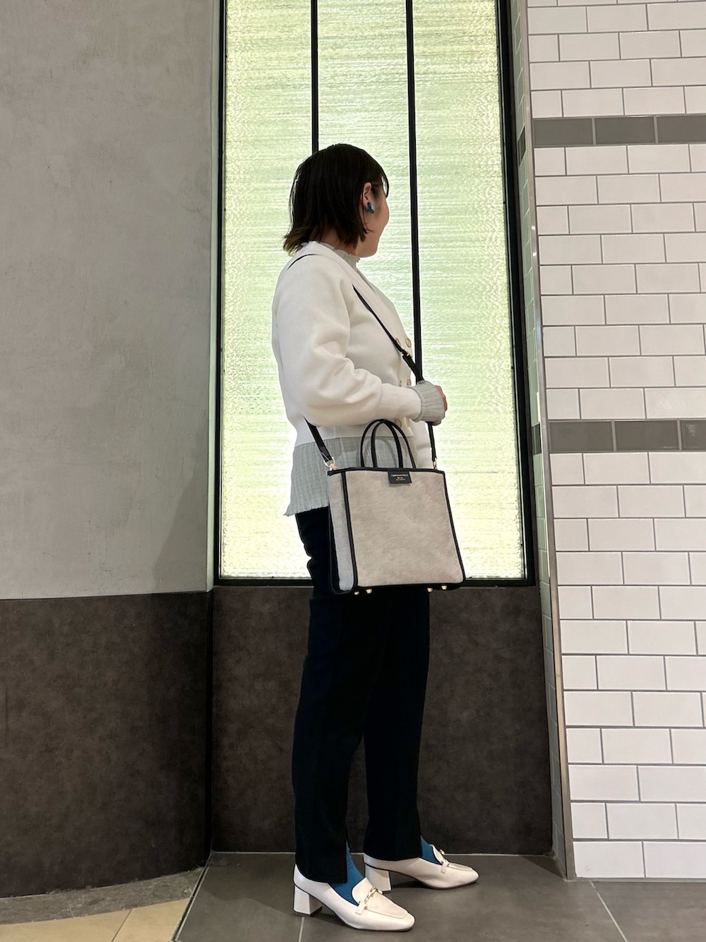 ホワイト系のカーディガン/ボレロ、グリーン系のTシャツ/カットソー、ブラック系のトートバッグを着用したレディースの春コーディネートの3枚目の写真