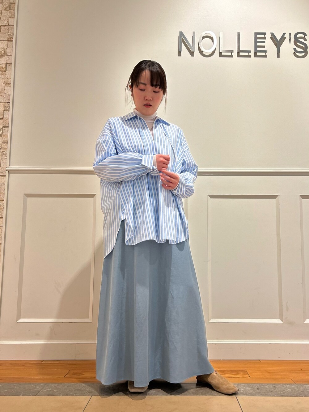 ブルー系のシャツ/ブラウス、ブルー系のスカート、ホワイト系のTシャツ/カットソーを着用したレディースの春コーディネートの6枚目の写真