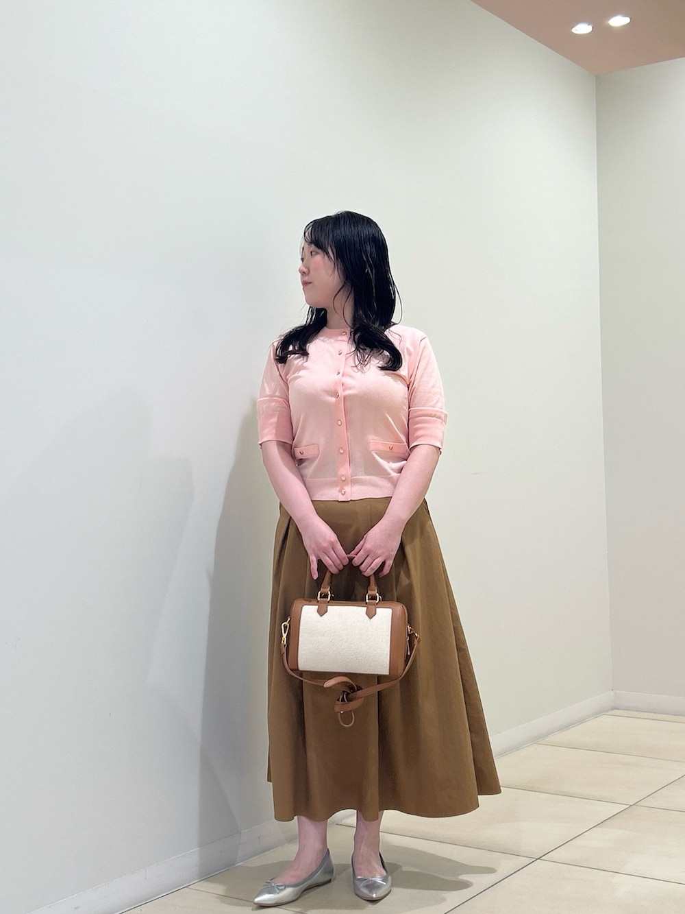 ピンク系のカーディガン/ボレロ、イエロー系のスカート、ブラウン系のボストンバッグを着用したレディースの夏コーディネートの8枚目の写真