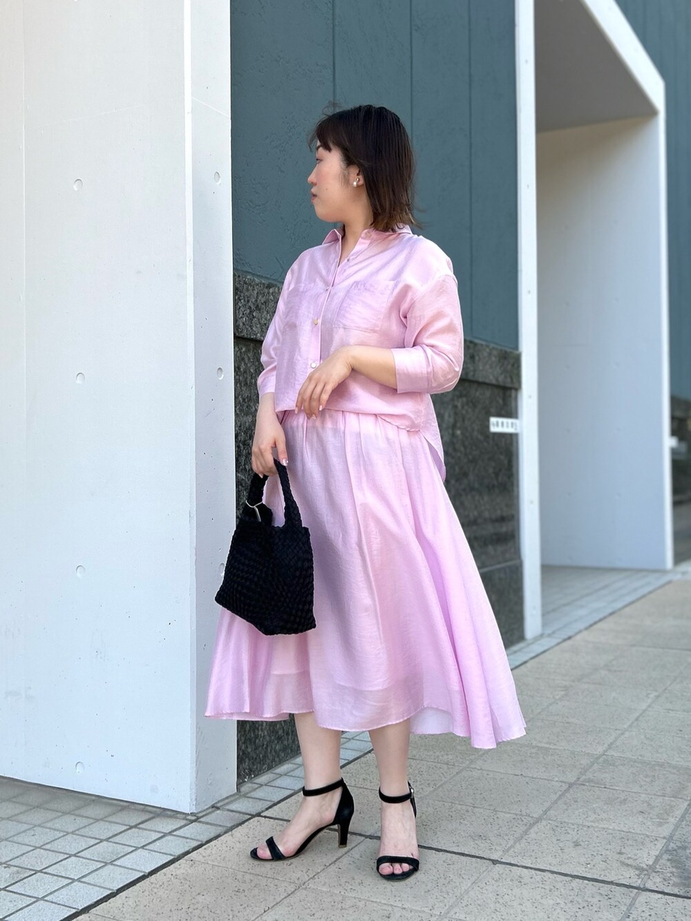 ピンク系のシャツ/ブラウス、ピンク系のスカート、ブラック系のショルダーバッグを着用したレディースの春コーディネートの6枚目の写真