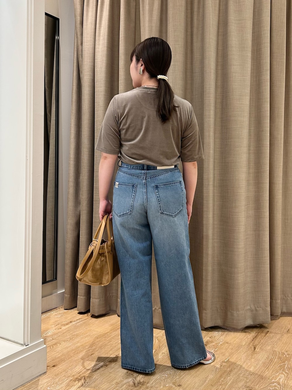 グリーン系のTシャツ/カットソー、ブルー系のデニムパンツ、イエロー系のトートバッグを着用したレディースの秋コーディネートの3枚目の写真