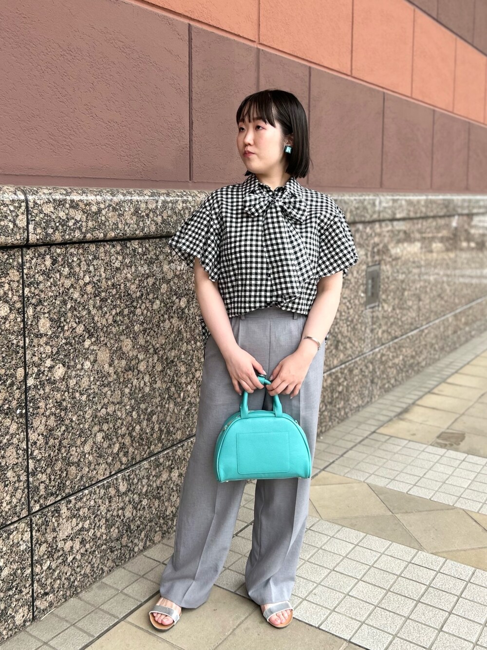 ブラック系のシャツ/ブラウス、グリーン系のボストンバッグ、グレー系のその他パンツを着用したレディースの夏コーディネートの2枚目の写真