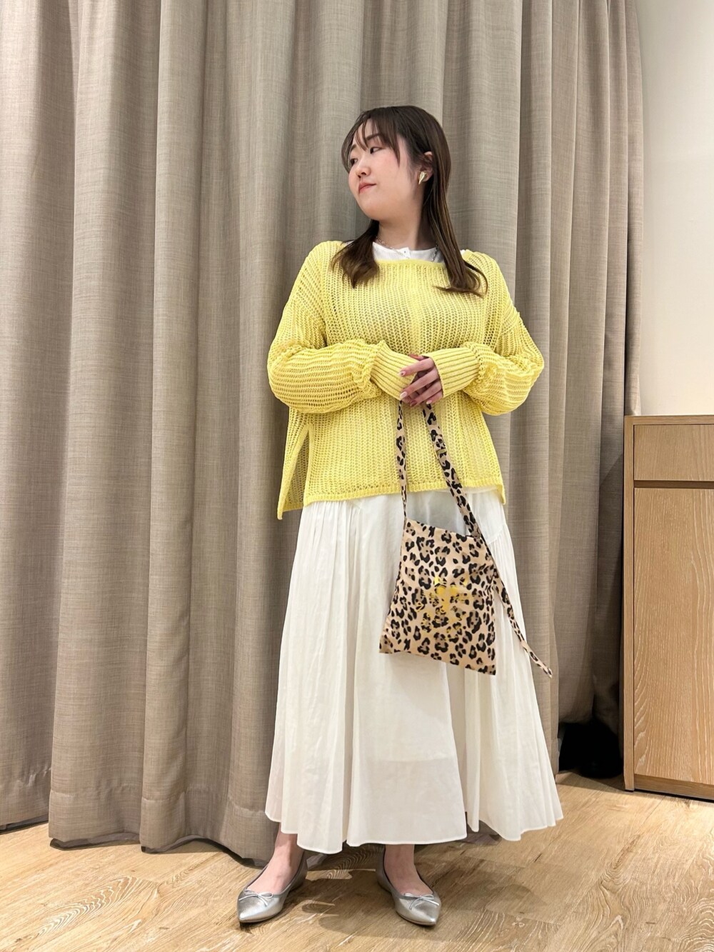 イエロー系のニット/セーター、ホワイト系のTシャツ/カットソー、ホワイト系のスカートを着用したレディースの春コーディネートの10枚目の写真
