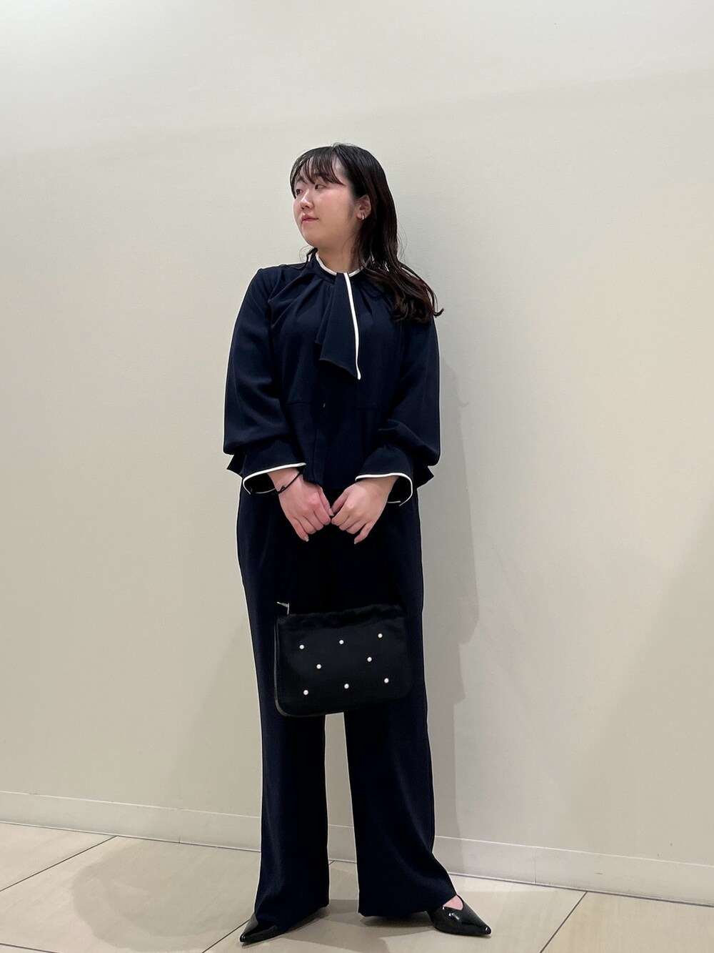 ブルー系のシャツ/ブラウス、ブルー系のその他パンツ、ブラック系のハンドバッグを着用したレディースの春コーディネートの6枚目の写真