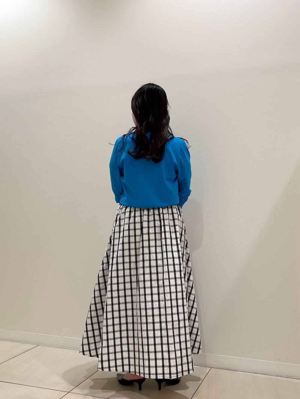 ブルー系のカーディガン/ボレロ、ホワイト系のスカート、ブラウン系のショルダーバッグを着用したレディースの春コーディネートの3枚目の写真