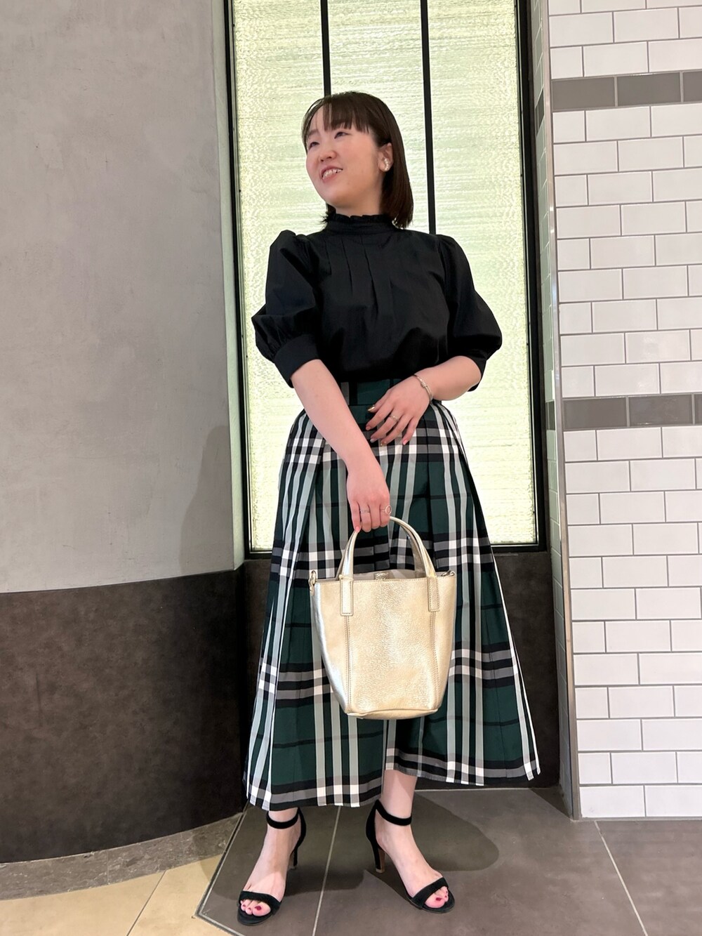 ブラック系のシャツ/ブラウス、グリーン系のスカート、ホワイト系のトートバッグを着用したレディースの夏コーディネートの7枚目の写真