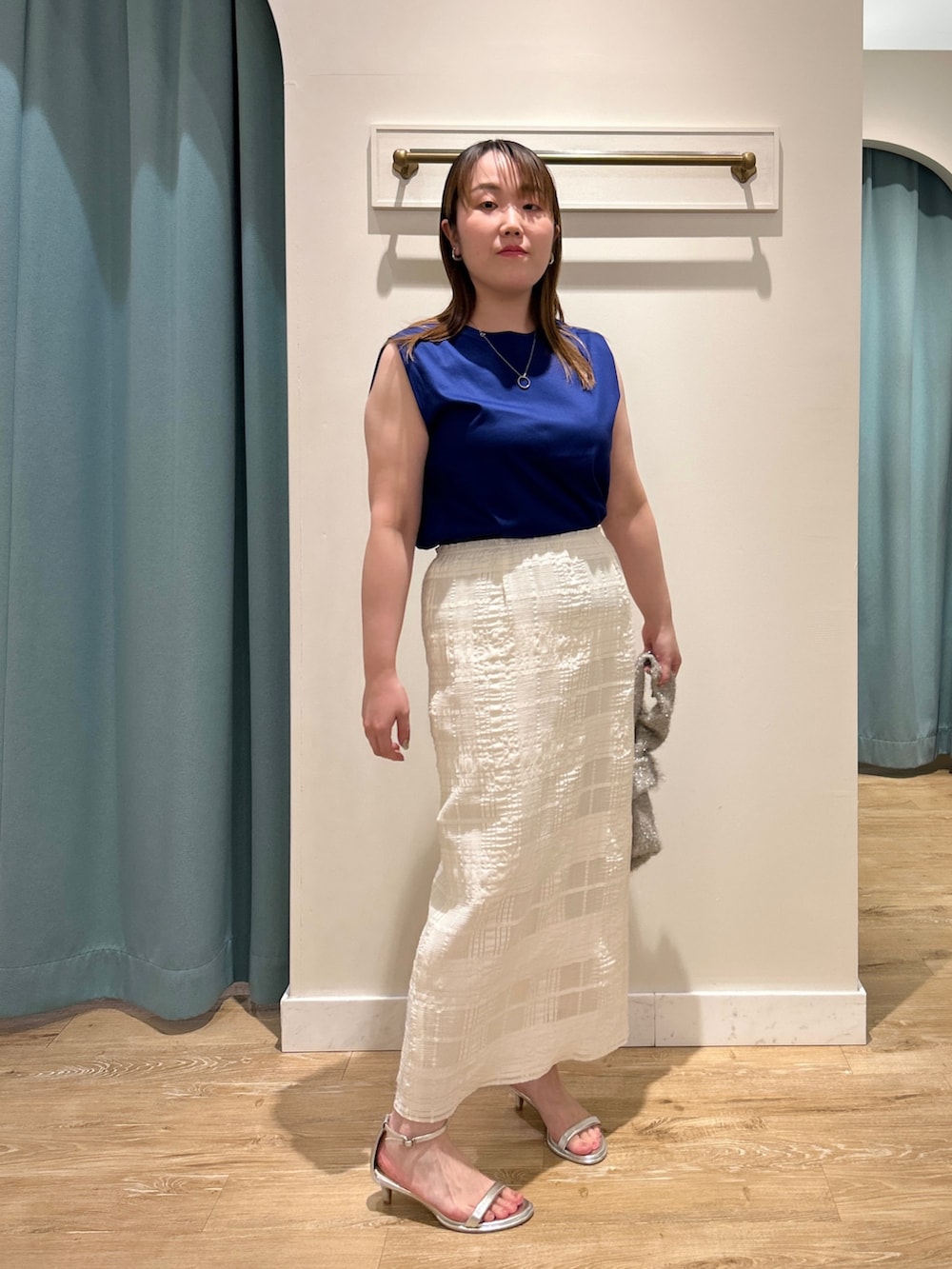 ブルー系のTシャツ/カットソー、ホワイト系のスカート、ベージュ系のバックパック/リュックを着用したレディースの夏コーディネートの2枚目の写真