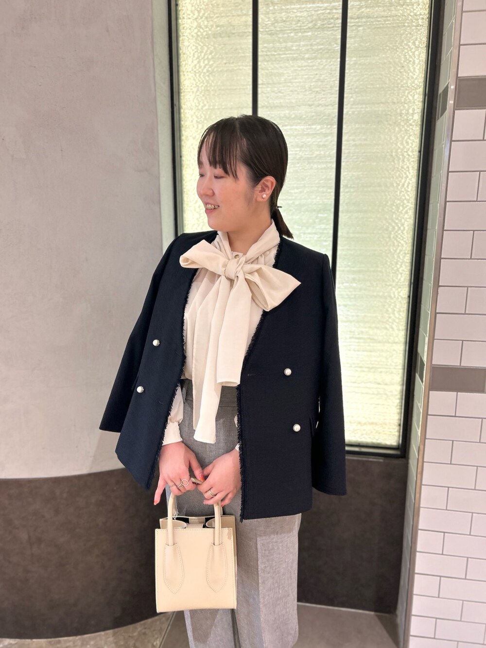 ブルー系のノーカラージャケット、ホワイト系のシャツ/ブラウス、グレー系のその他パンツを着用したレディースの秋コーディネートの9枚目の写真