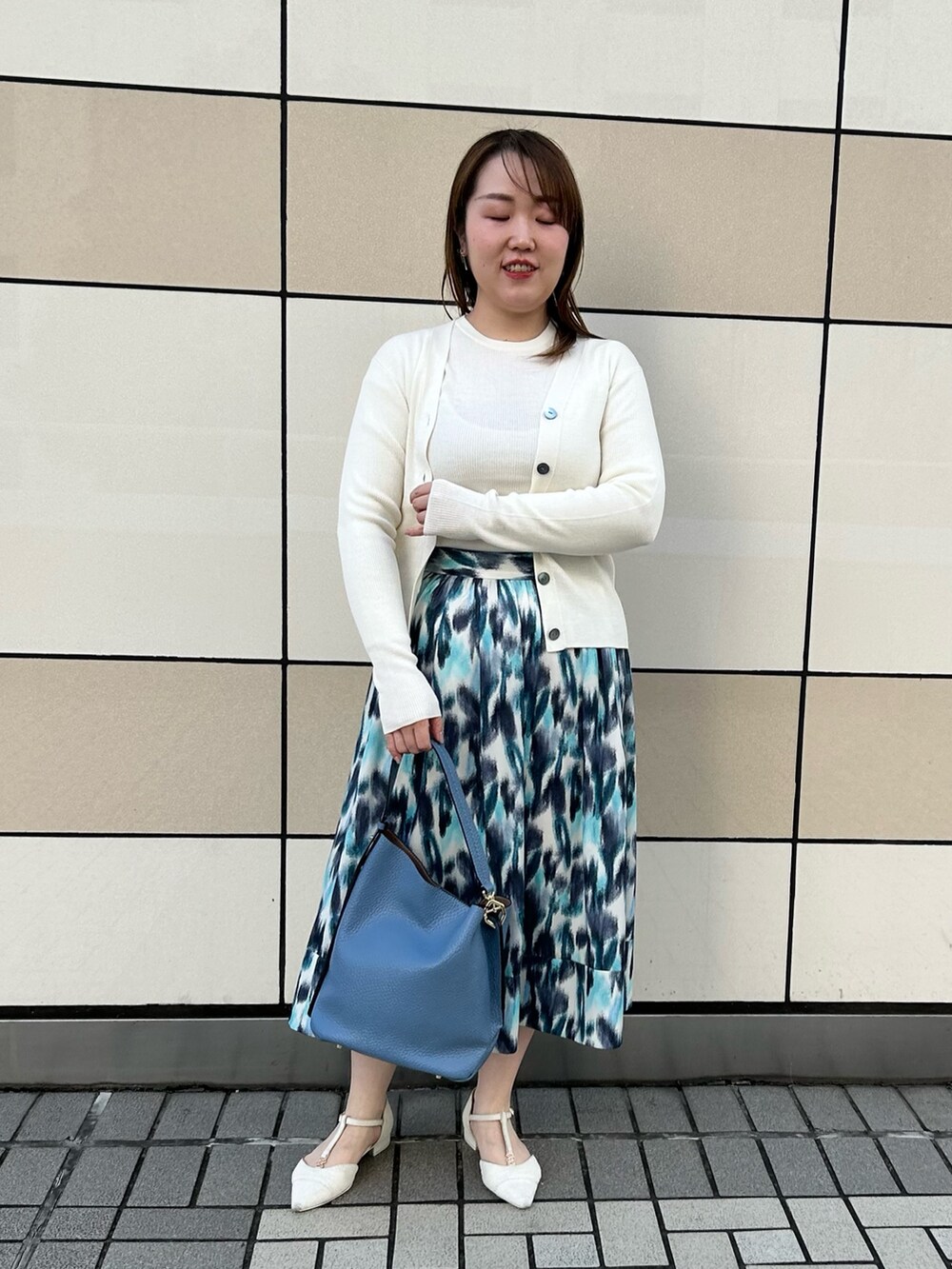ホワイト系のカーディガン/ボレロ、ホワイト系のニット/セーター、ブルー系のスカートを着用したレディースの秋コーディネートの8枚目の写真
