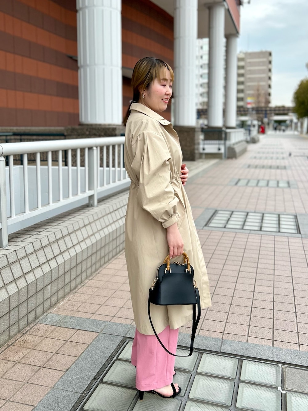 ベージュ系のその他アウター、ブラック系のニット/セーター、ピンク系のチノパンツを着用したレディースの春コーディネートの6枚目の写真