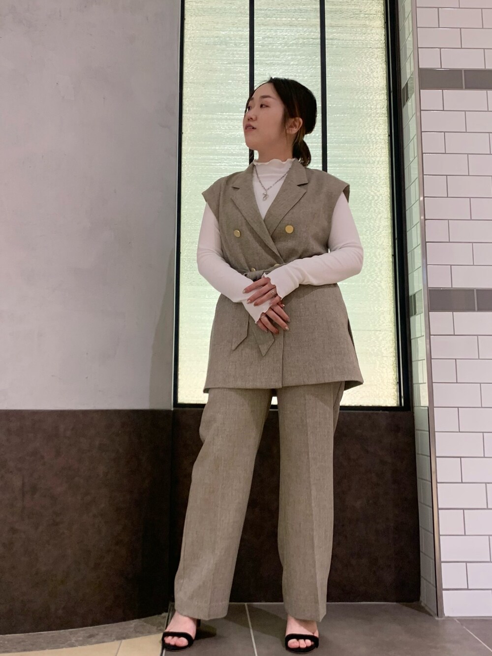 ベージュ系のベスト、ベージュ系のその他パンツ、ホワイト系のTシャツ/カットソーを着用したレディースの冬コーディネートの2枚目の写真