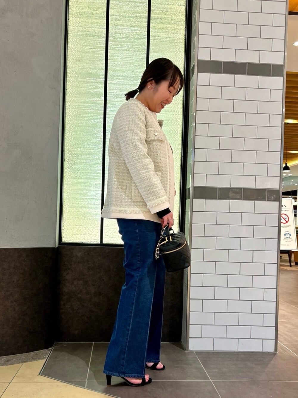 ホワイト系のノーカラージャケット、ブラック系のTシャツ/カットソー、ブルー系のデニムパンツを着用したレディースの夏コーディネートの5枚目の写真