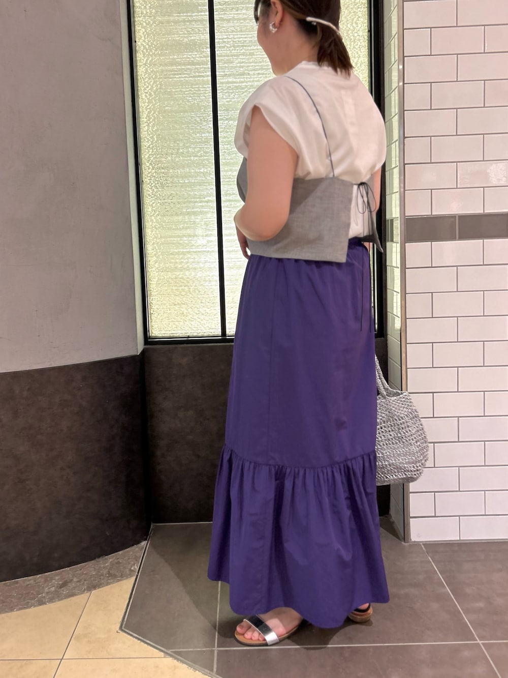 グレー系のTシャツ/カットソー、パープル系のスカート、シルバー系のバックパック/リュックを着用したレディースの夏コーディネートの3枚目の写真