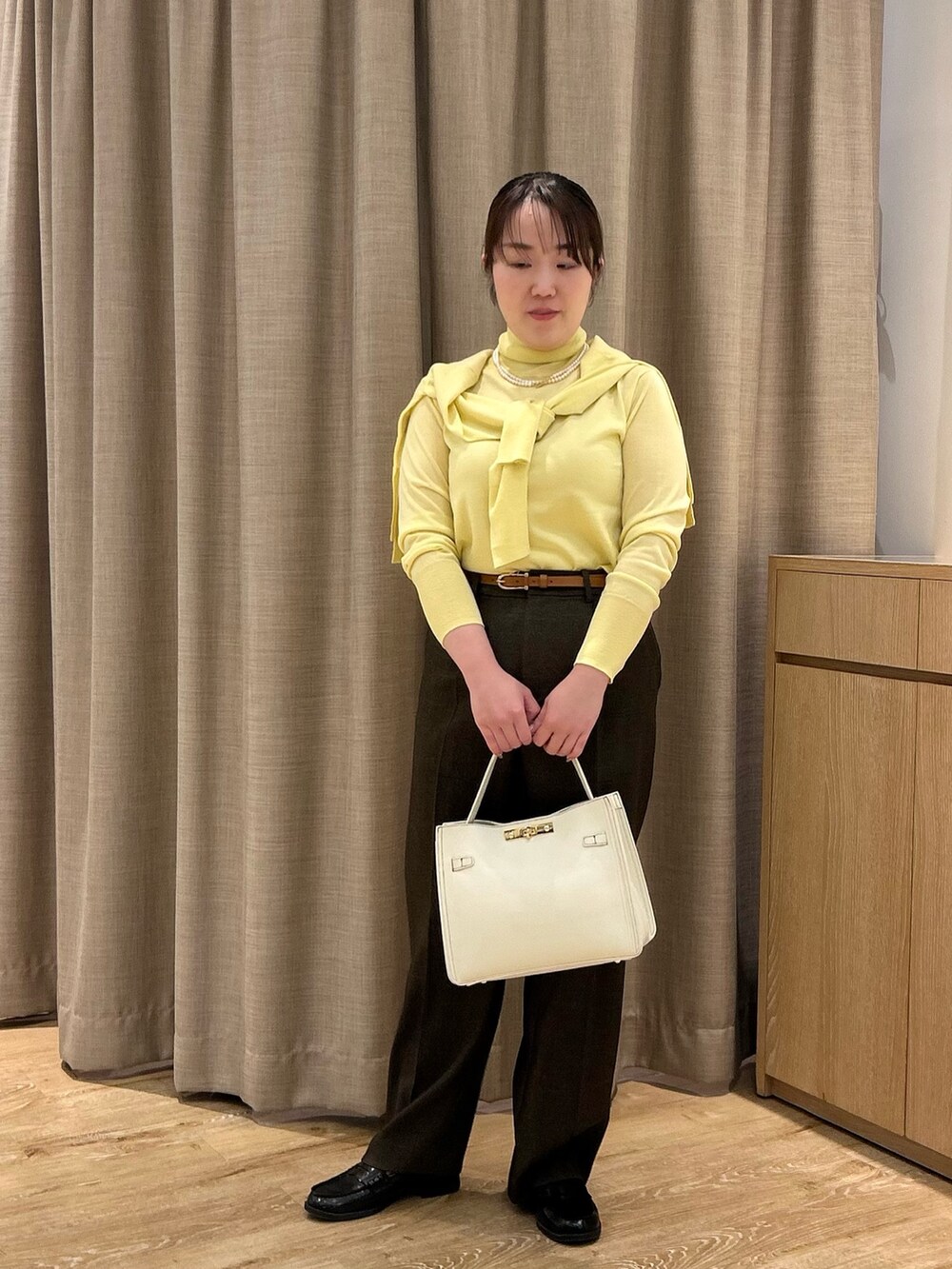 イエロー系のニット/セーター、イエロー系のカーディガン/ボレロ、ブラウン系のその他パンツを着用したレディースの秋コーディネートの5枚目の写真