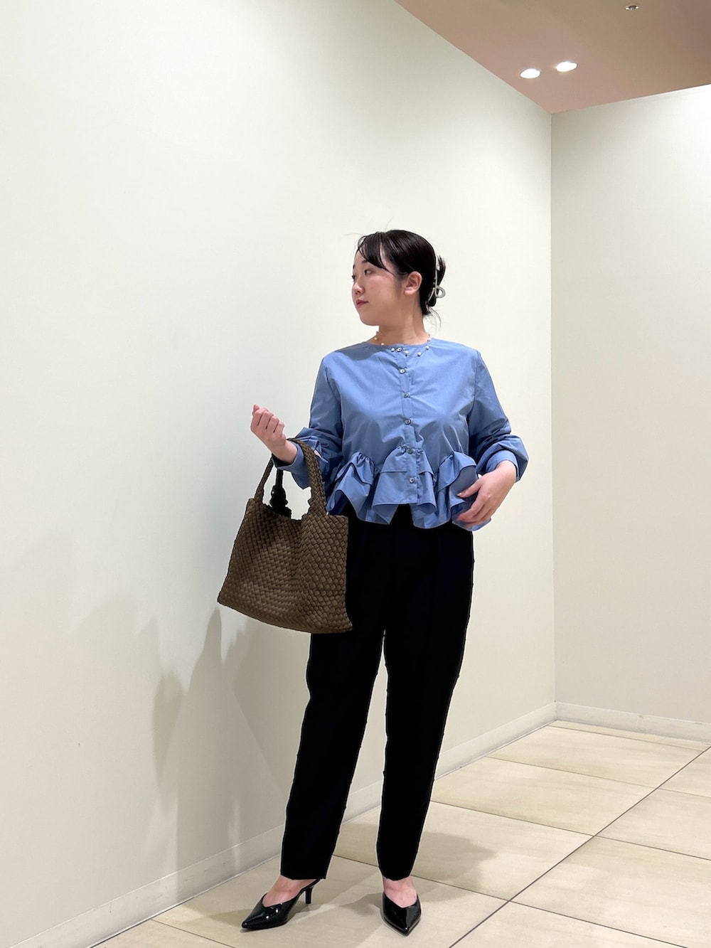 ブルー系のシャツ/ブラウス、ブラック系のその他パンツ、ブラウン系のトートバッグを着用したレディースの秋コーディネートの9枚目の写真