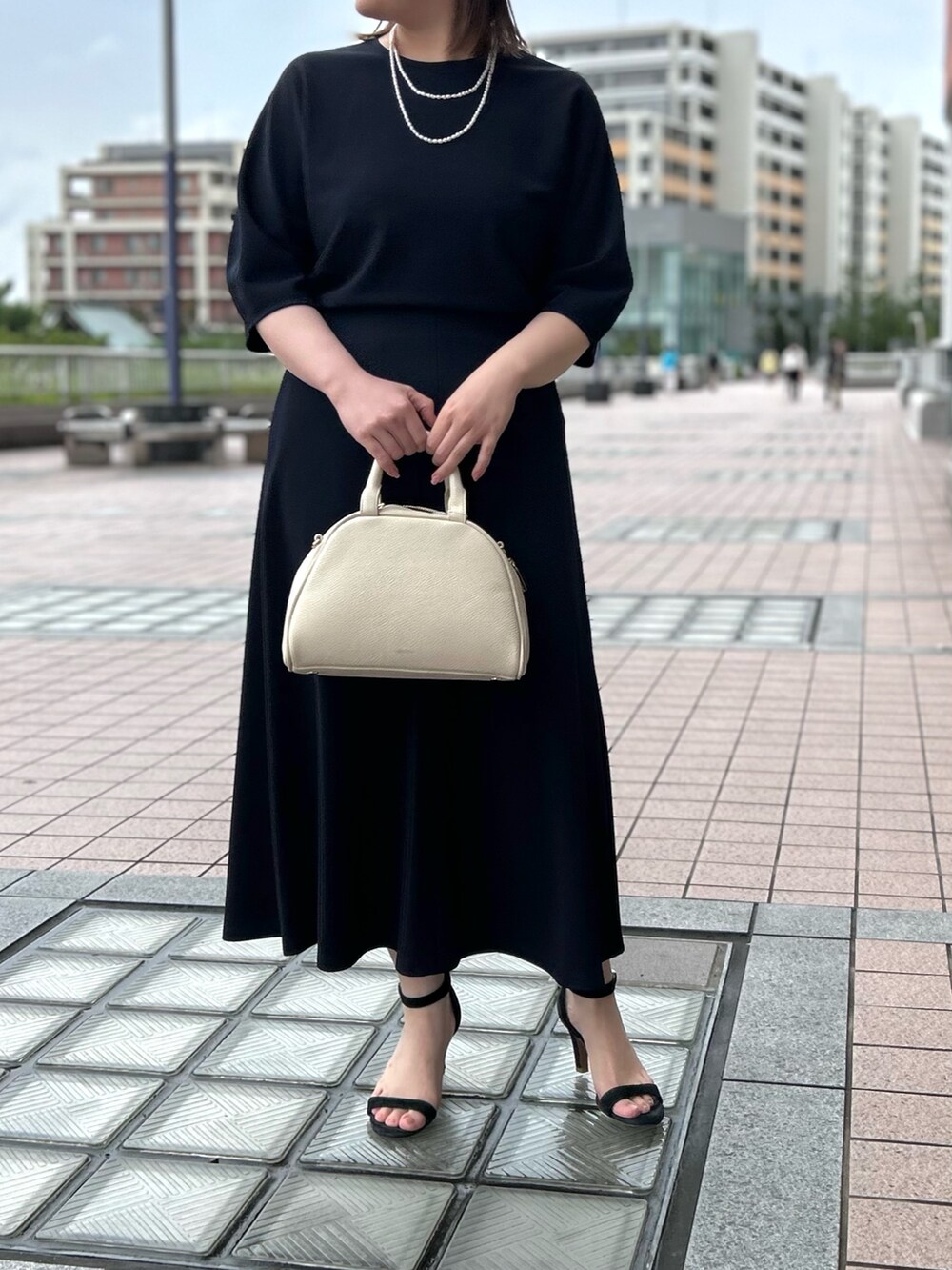 ブルー系のTシャツ/カットソー、ブルー系のスカート、ホワイト系のボストンバッグを着用したレディースの春コーディネートの5枚目の写真