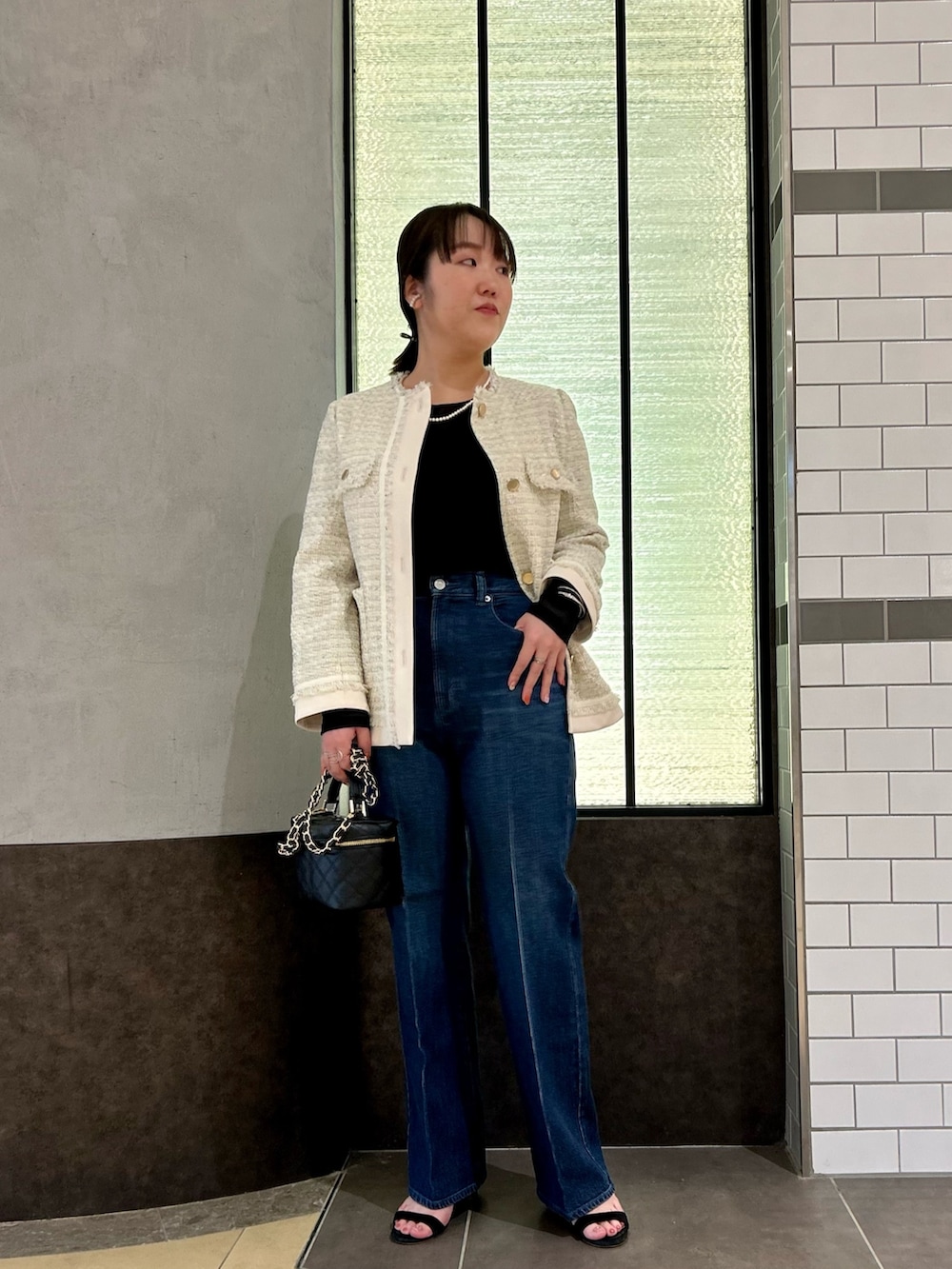 ホワイト系のノーカラージャケット、ブラック系のTシャツ/カットソー、ブルー系のデニムパンツを着用したレディースの夏コーディネートの9枚目の写真