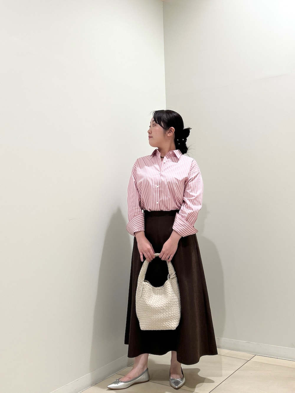 ピンク系のシャツ/ブラウス、ブラウン系のスカート、ホワイト系のショルダーバッグを着用したレディースの秋コーディネートの10枚目の写真