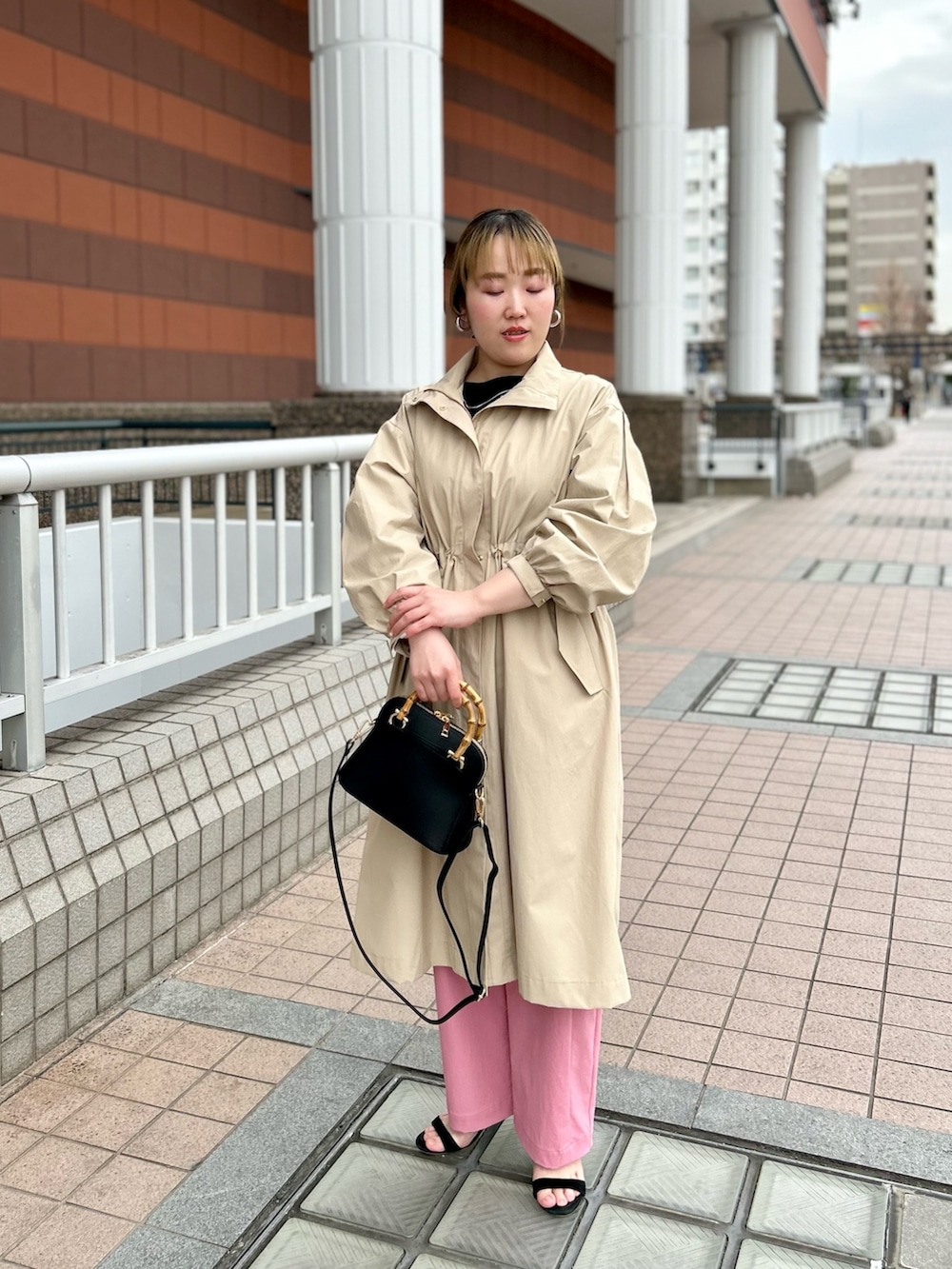 ベージュ系のその他アウター、ブラック系のニット/セーター、ピンク系のチノパンツを着用したレディースの春コーディネートの8枚目の写真