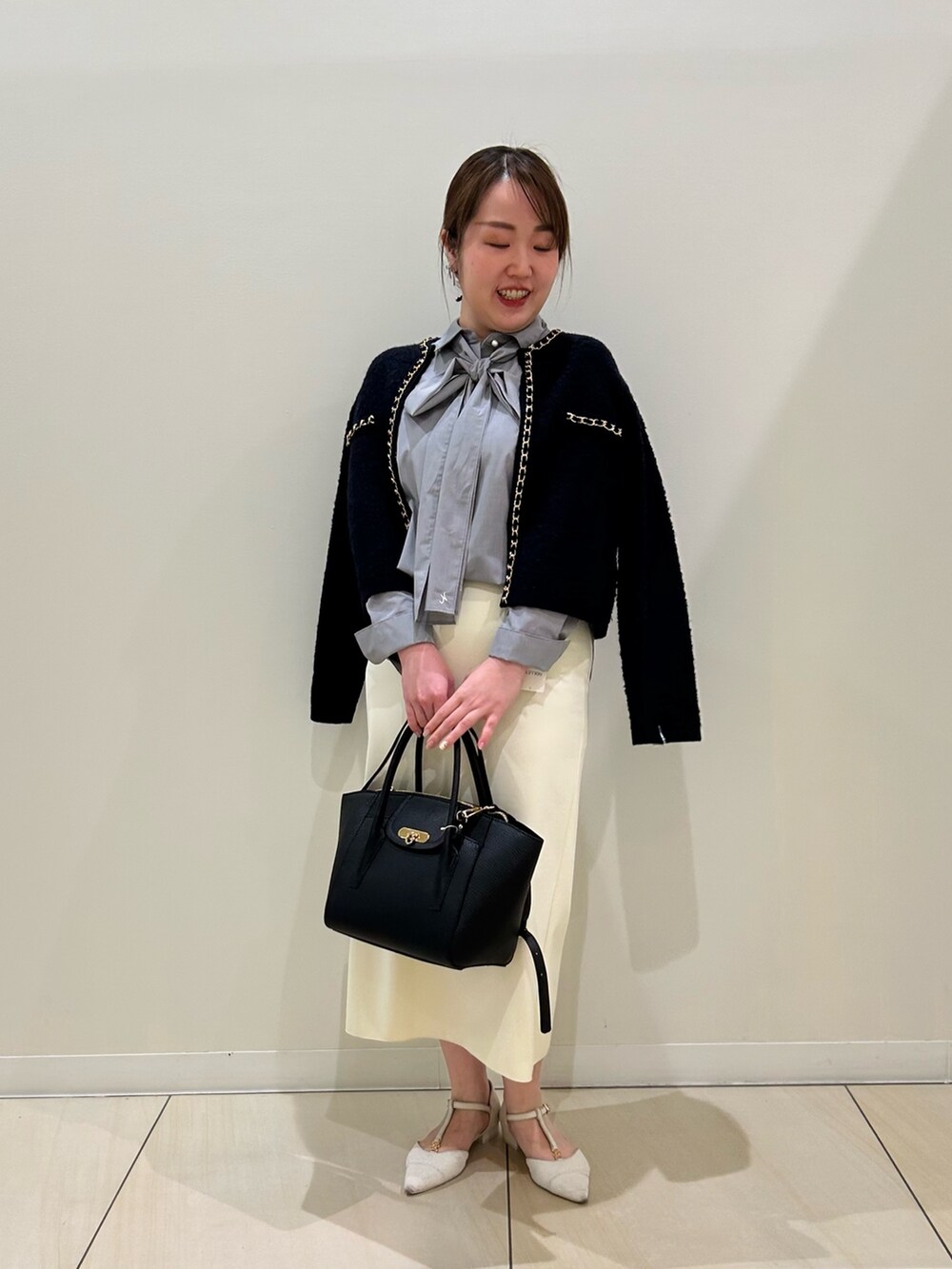 ブルー系のカーディガン/ボレロ、グレー系のシャツ/ブラウス、ホワイト系のスカートを着用したレディースの秋コーディネートの7枚目の写真