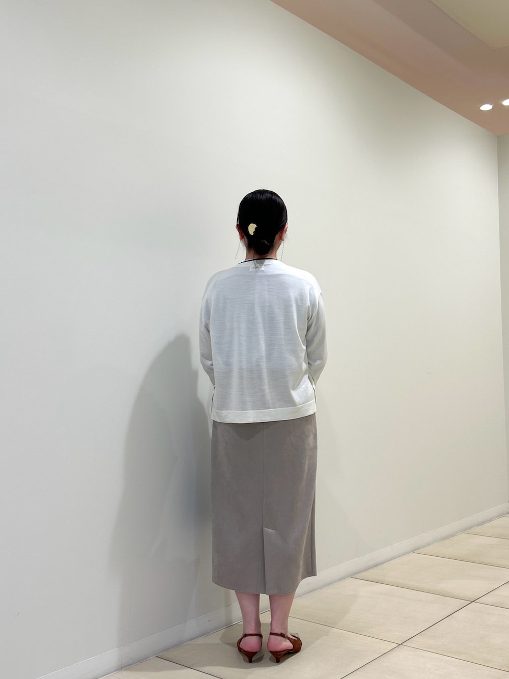 ホワイト系のカーディガン/ボレロ、ブルー系のシャツ/ブラウス、ベージュ系のスカートを着用したレディースの秋コーディネートの3枚目の写真