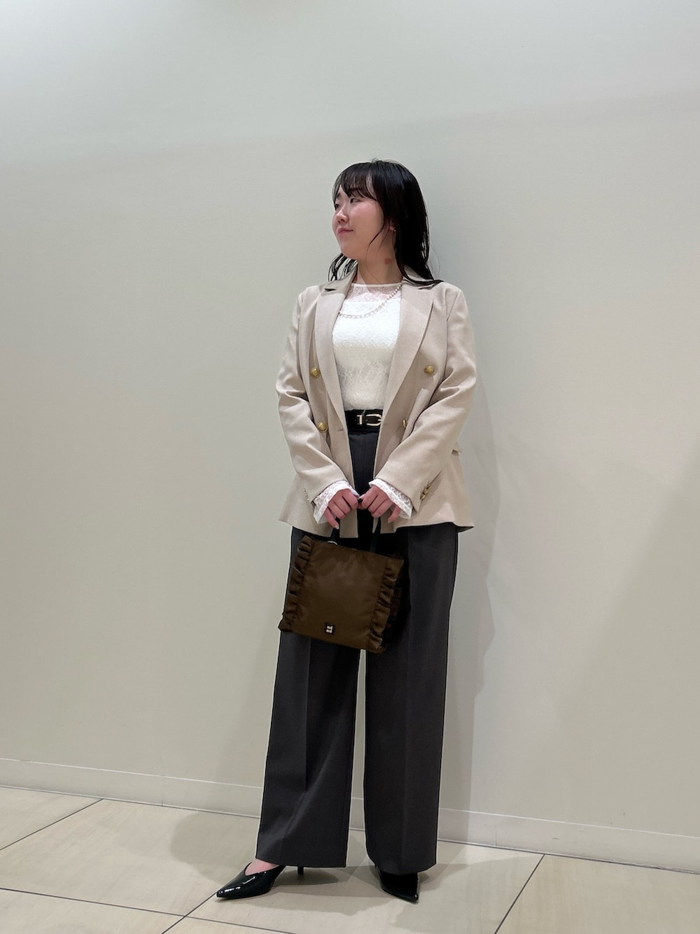 ベージュ系のテーラードジャケット、グレー系のその他パンツ、ホワイト系のTシャツ/カットソーを着用したレディースの春コーディネートの10枚目の写真