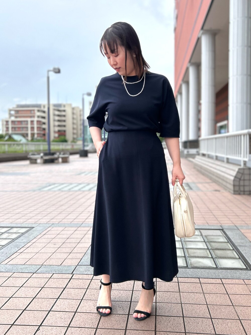 ブルー系のTシャツ/カットソー、ブルー系のスカート、ホワイト系のボストンバッグを着用したレディースの春コーディネートの6枚目の写真