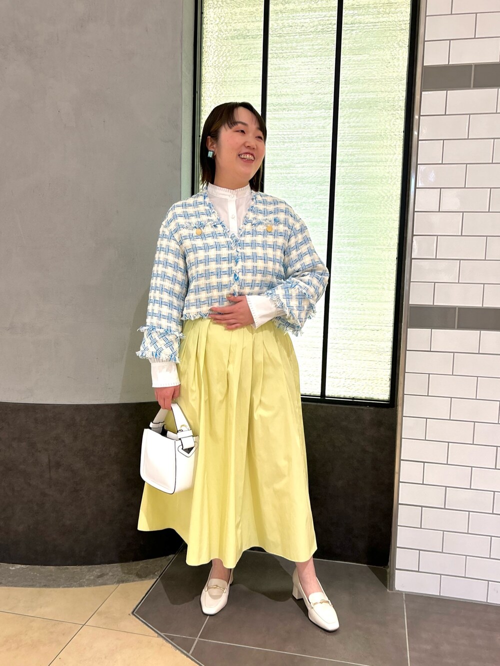 ブルー系のノーカラージャケット、ホワイト系のシャツ/ブラウス、ホワイト系のショルダーバッグを着用したレディースの冬コーディネートの6枚目の写真