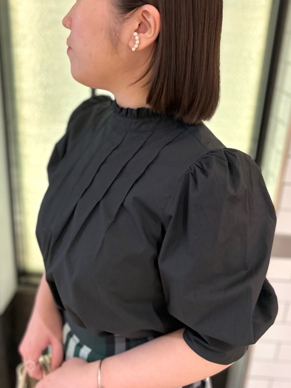 ブラック系のシャツ/ブラウス、グリーン系のスカート、ホワイト系のトートバッグを着用したレディースの夏コーディネートの10枚目の写真