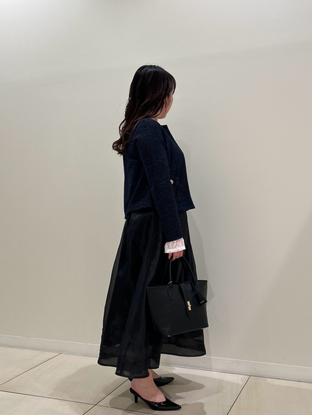 ブルー系のノーカラージャケット、ブラック系のスカート、ホワイト系のTシャツ/カットソーを着用したレディースの春コーディネートの4枚目の写真