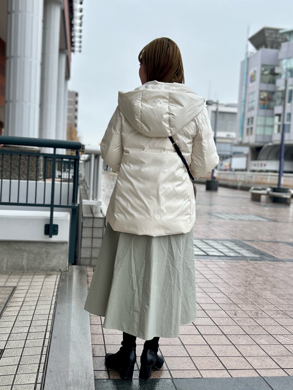 ホワイト系のダウンジャケット/コート、グレー系のワンピース、シルバー系のニット/セーターを着用したレディースの冬コーディネートの5枚目の写真