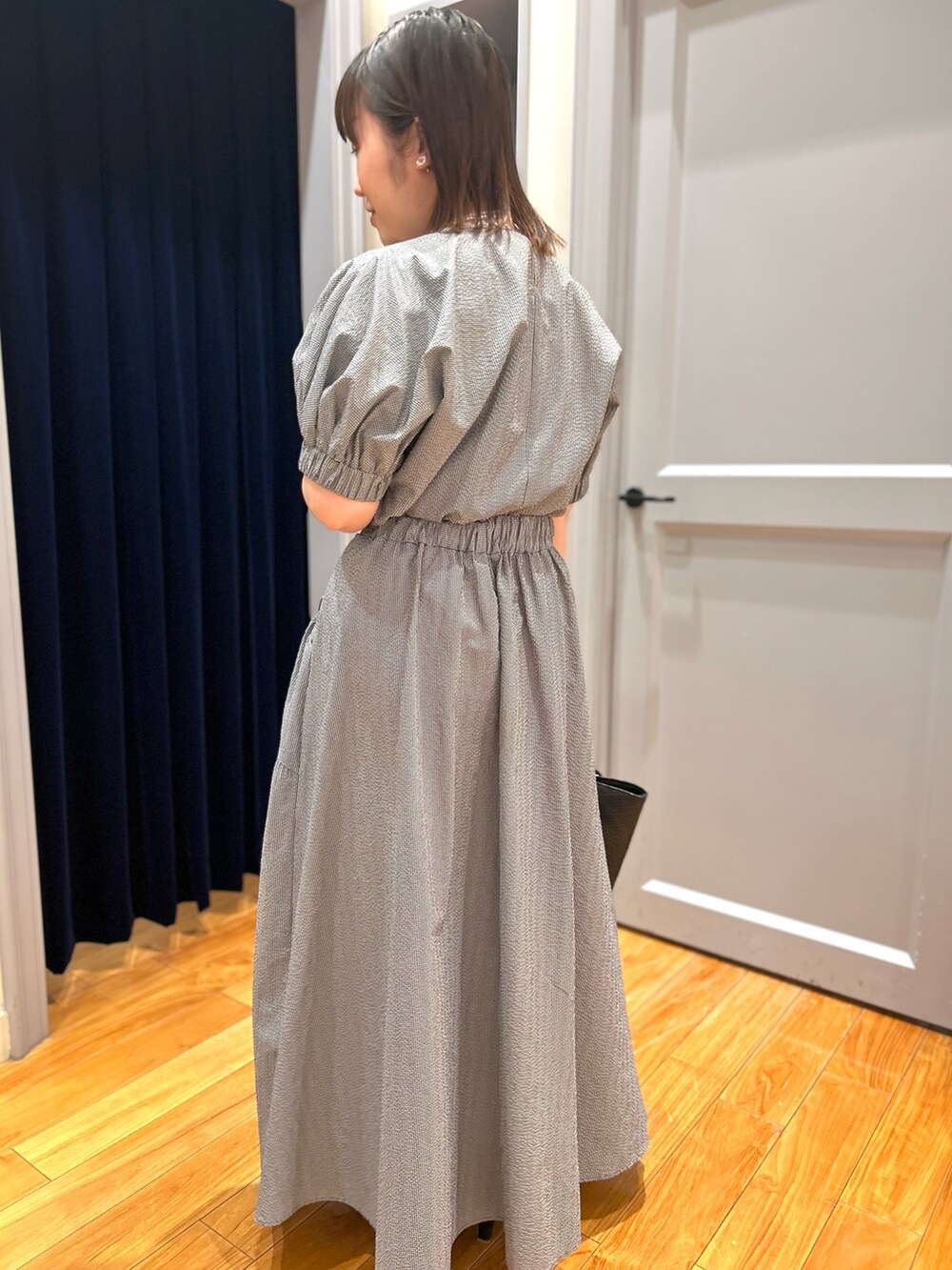 グレー系のシャツ/ブラウス、グレー系のスカート、ブラック系のかごバッグを着用したレディースの夏コーディネートの10枚目の写真