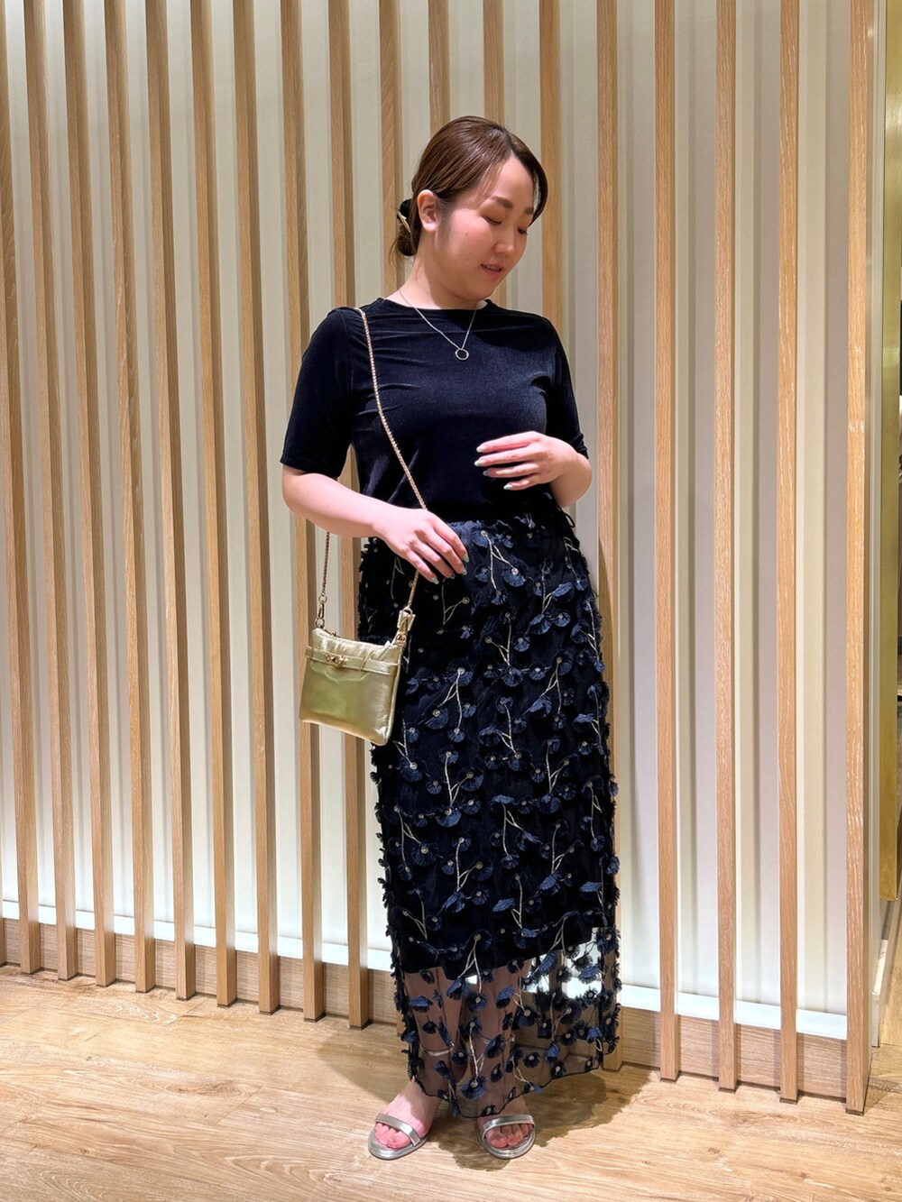 ブルー系のTシャツ/カットソー、ブルー系のスカート、ゴールド系のショルダーバッグを着用したレディースの秋コーディネートの6枚目の写真