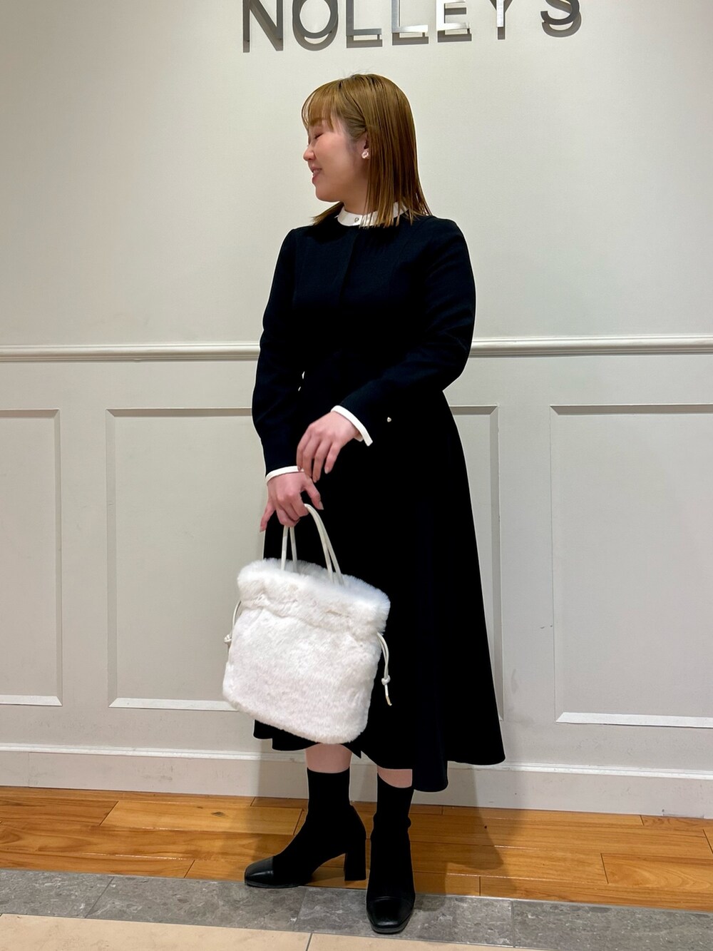 ブルー系のワンピース、ホワイト系のショルダーバッグ、ホワイト系のイヤリングを着用したレディースの冬コーディネートの5枚目の写真