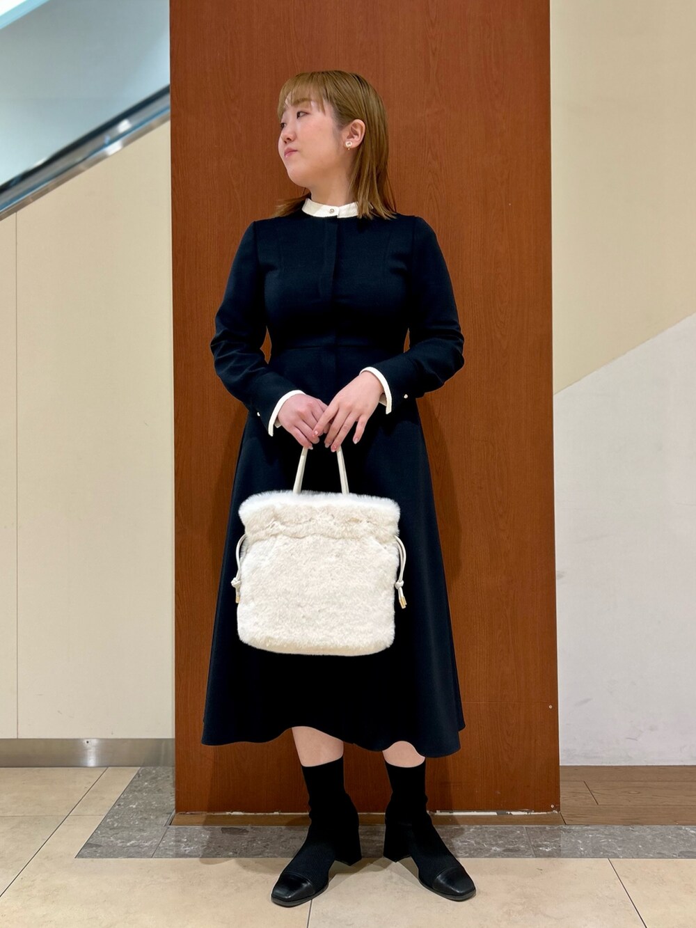 ブルー系のワンピース、ホワイト系のショルダーバッグ、ホワイト系のイヤリングを着用したレディースの冬コーディネートの10枚目の写真