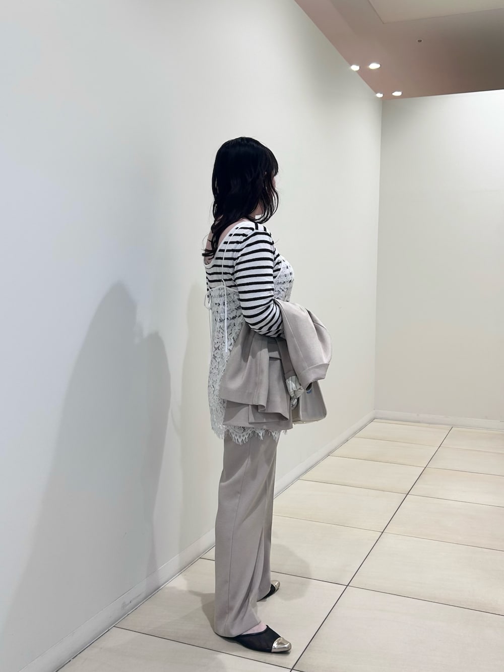 ホワイト系のキャミソール、ホワイト系のニット/セーター、ベージュ系のテーラードジャケットを着用したレディースの春コーディネートの4枚目の写真