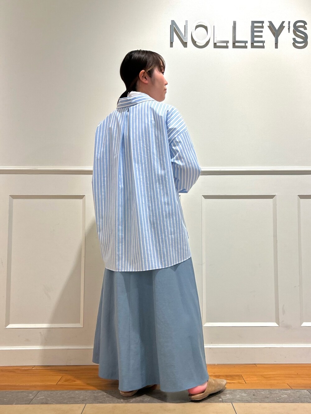 ブルー系のシャツ/ブラウス、ブルー系のスカート、ホワイト系のTシャツ/カットソーを着用したレディースの春コーディネートの2枚目の写真