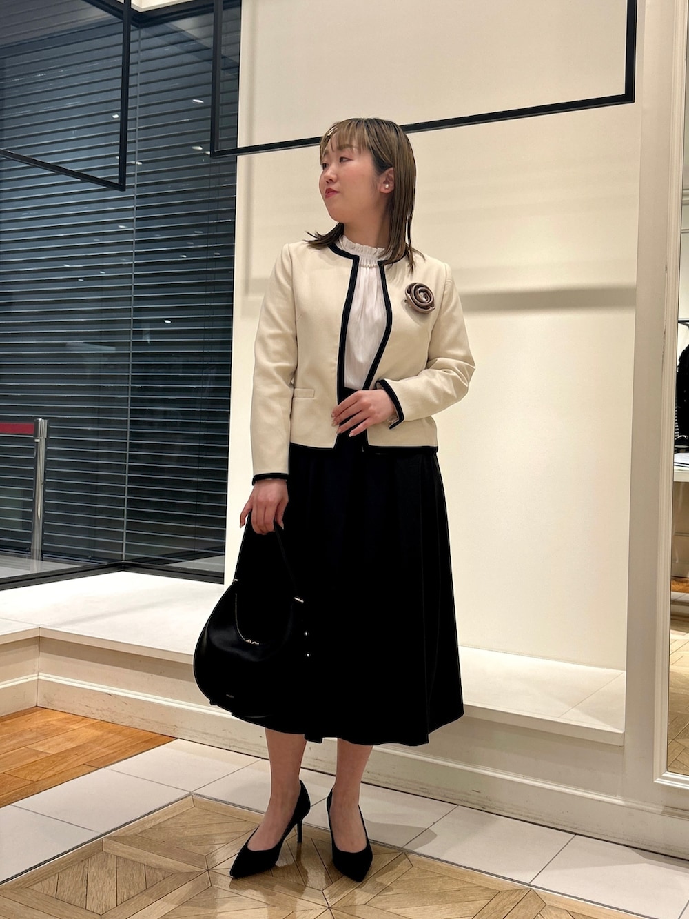 ホワイト系のノーカラージャケット、ホワイト系のシャツ/ブラウス、ブラック系のショルダーバッグを着用したレディースの冬コーディネートの7枚目の写真