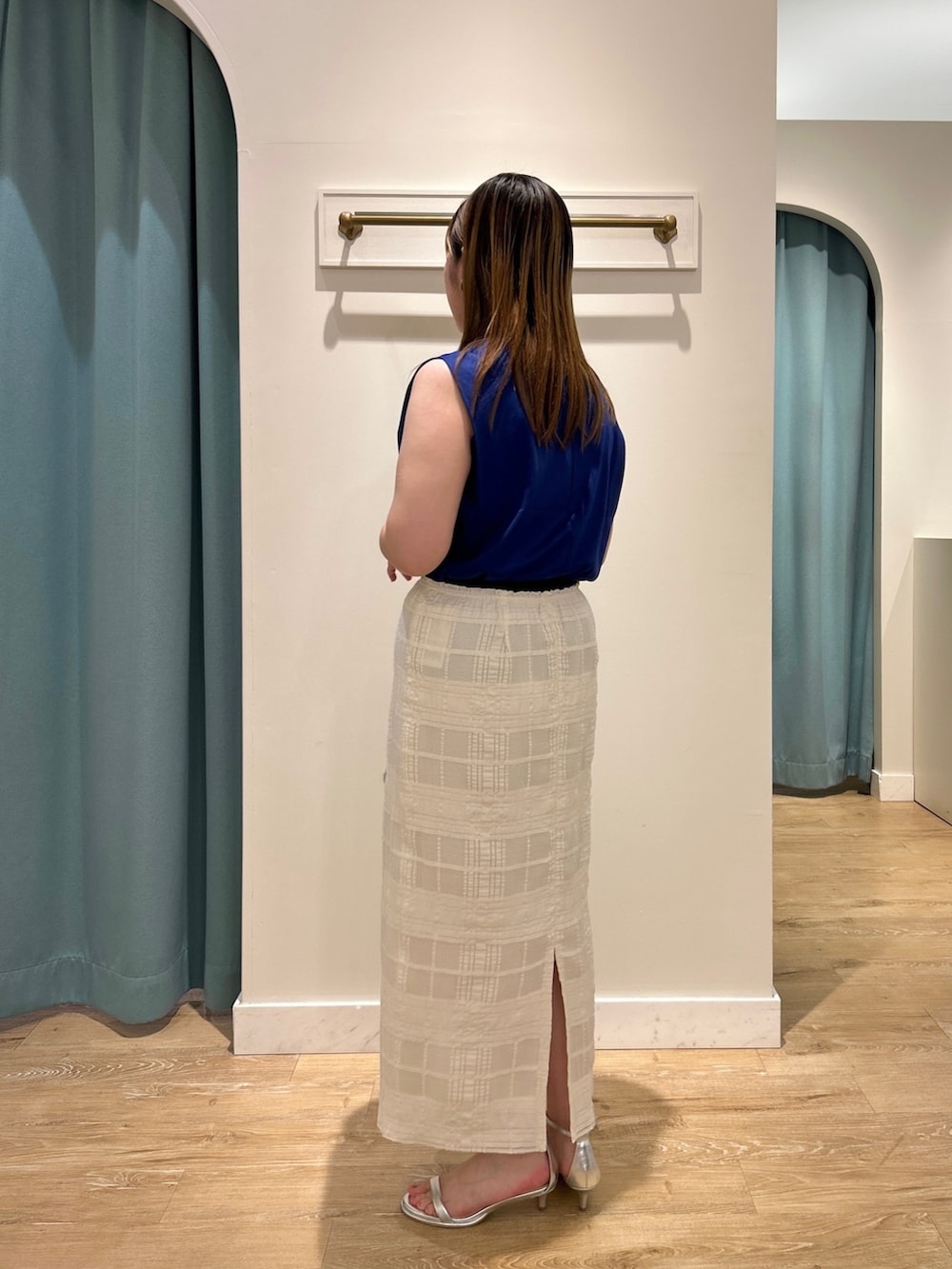 ブルー系のTシャツ/カットソー、ホワイト系のスカート、ベージュ系のバックパック/リュックを着用したレディースの夏コーディネートの4枚目の写真