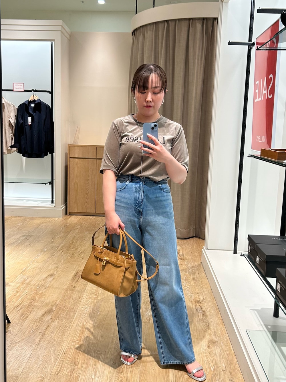 グリーン系のTシャツ/カットソー、ブルー系のデニムパンツ、イエロー系のトートバッグを着用したレディースの秋コーディネートの9枚目の写真
