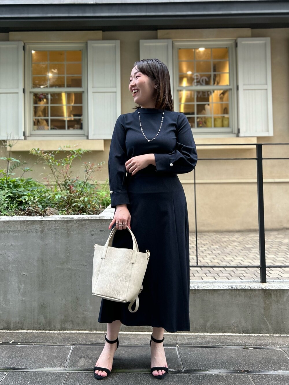 ブルー系のシャツ/ブラウス、ブルー系のスカート、ホワイト系のトートバッグを着用したレディースの秋コーディネートの8枚目の写真