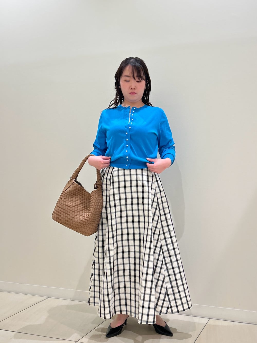 ブルー系のカーディガン/ボレロ、ホワイト系のスカート、ブラウン系のショルダーバッグを着用したレディースの春コーディネートの7枚目の写真