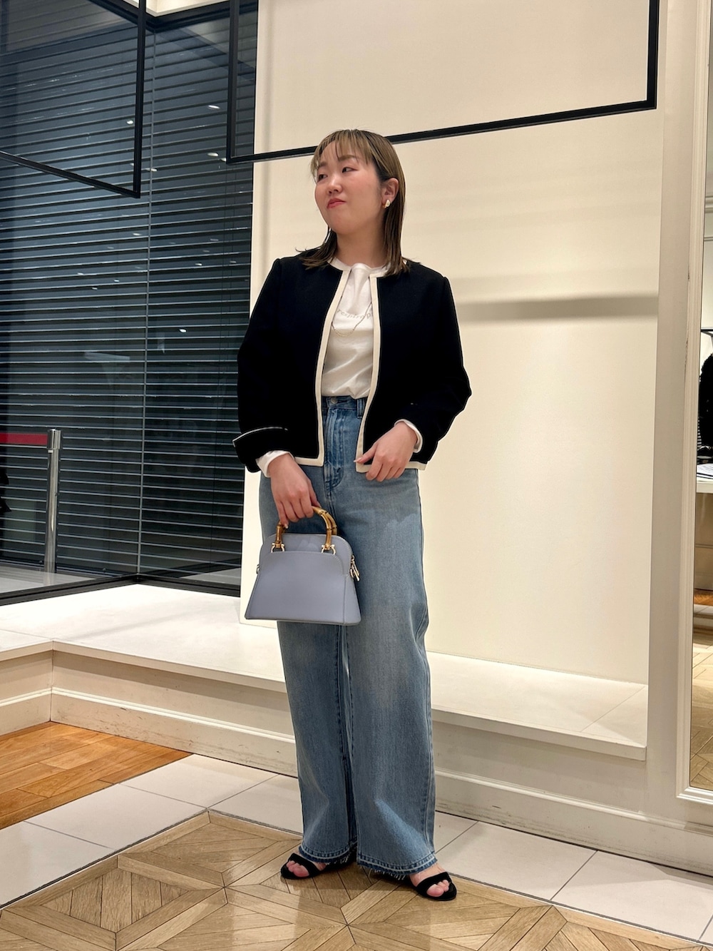 ブラック系のノーカラージャケット、ホワイト系のTシャツ/カットソー、ブルー系のデニムパンツを着用したレディースの冬コーディネートの8枚目の写真