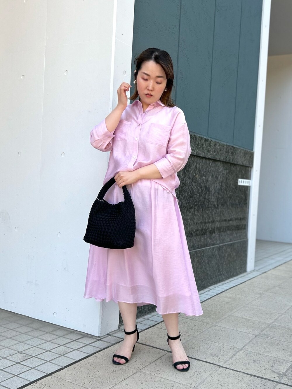 ピンク系のシャツ/ブラウス、ピンク系のスカート、ブラック系のショルダーバッグを着用したレディースの春コーディネートの7枚目の写真