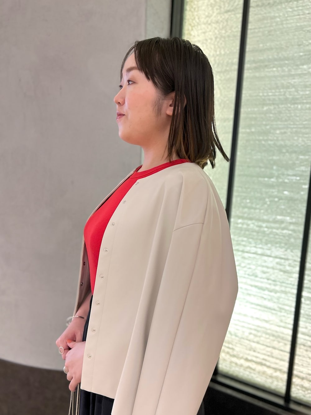 ベージュ系のブルゾン、レッド系のTシャツ/カットソー、ブラック系のスカートを着用したレディースの秋コーディネートの8枚目の写真